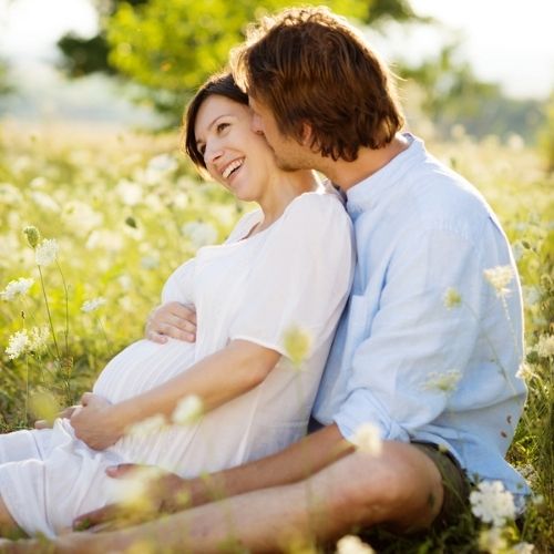 Pregnant couple in meadow