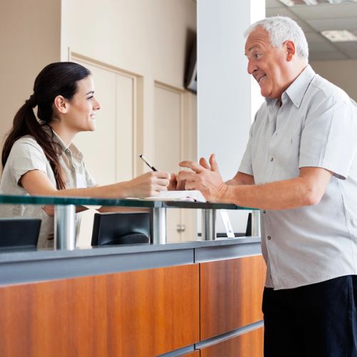 Patient speaking to receptionist 500x500